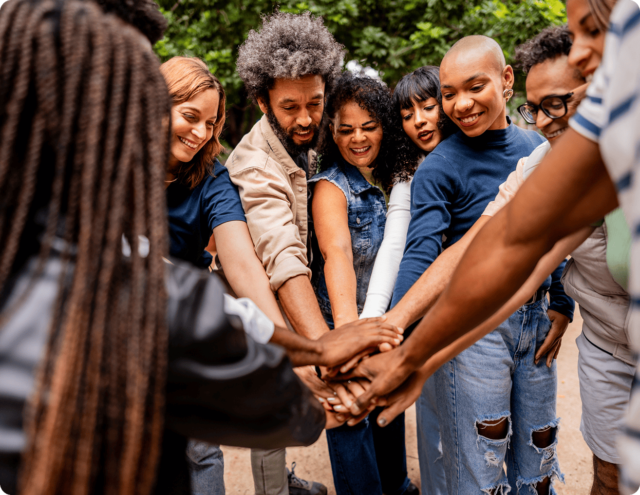 Group of diverse people standing in a circle, their hands joined together in a show of unity and togetherness